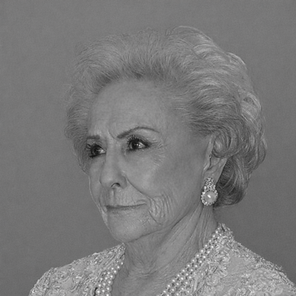 Retrato en blanco y negro de Mª Teresa Cuadra Garrido, mujer de cabello cano y perlas.